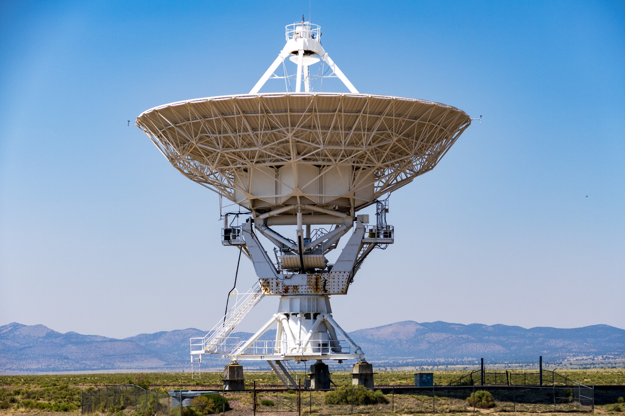 White Satellite Dish on Green Grass Field Under Blue Sky