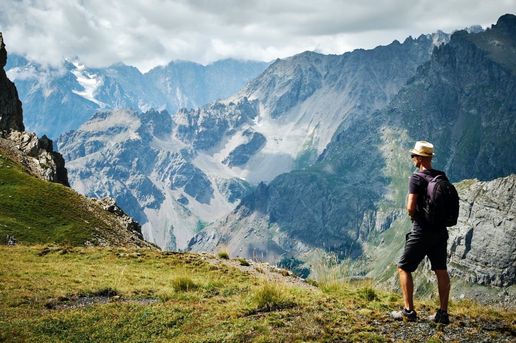 photo of man standing near mountains